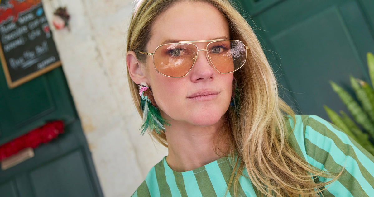 Model wearing feather and bird shaped earrings