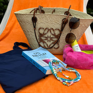 Pink Pouch Styled by the Pool with a Book and Jewelry