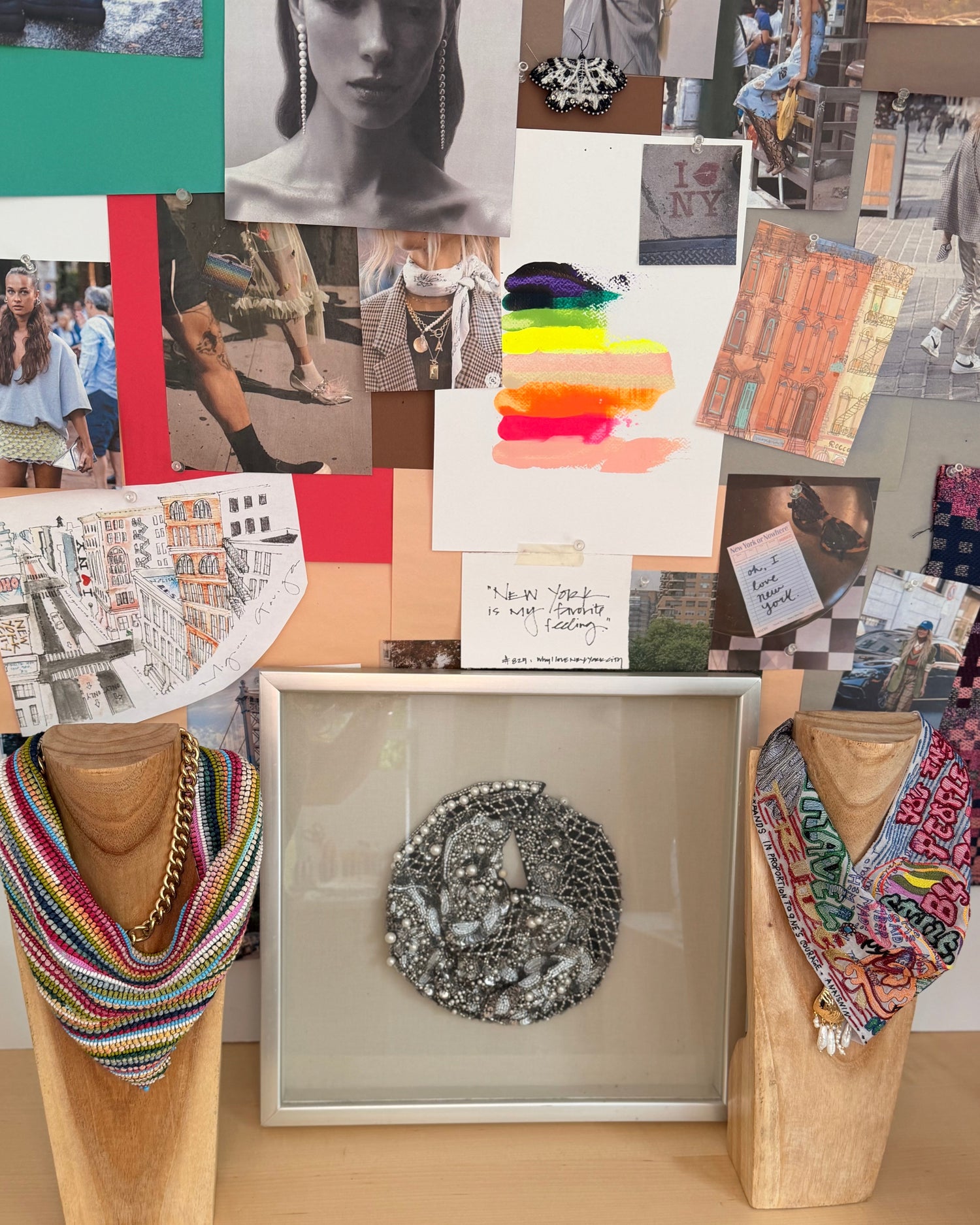Mannequin with colorful scarf, decorative brooch, and patterned paper in the background