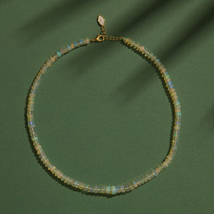 Iridescent Opal Strand Necklace Staged on Green Background 