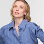 Woman wearing a blue pinstripe shirt against a plain background