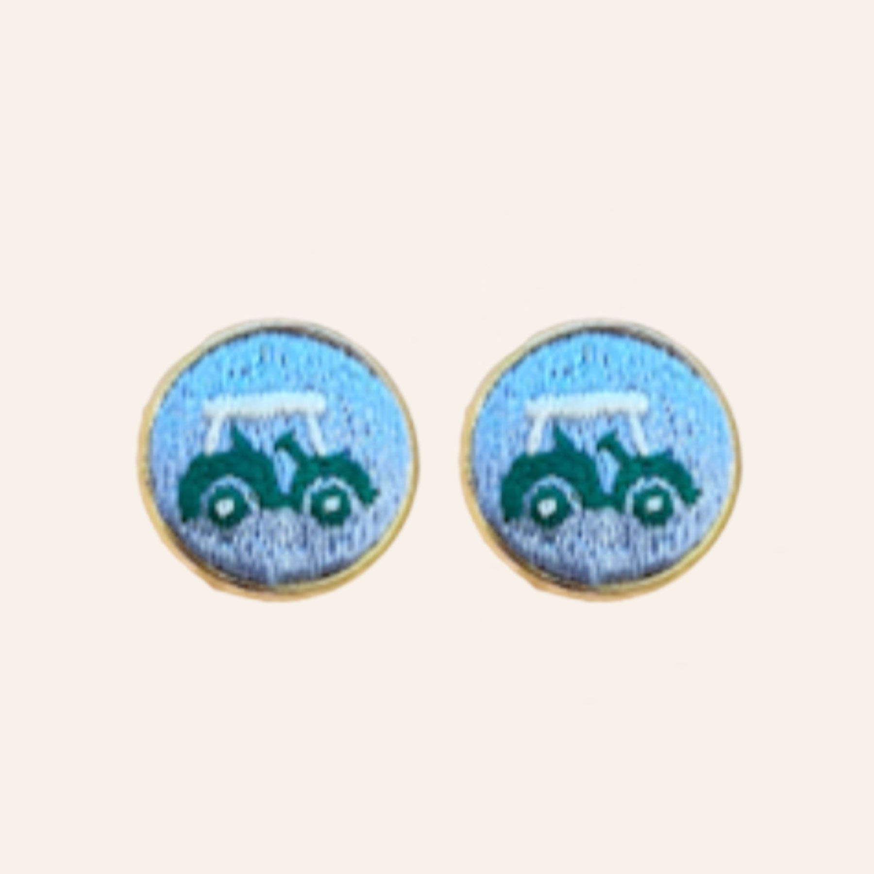 Blue golf cart embroidered cuff links on tan background