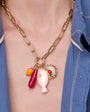 Gold Chain Necklace with colorful charms worn by a person in a blue shirt