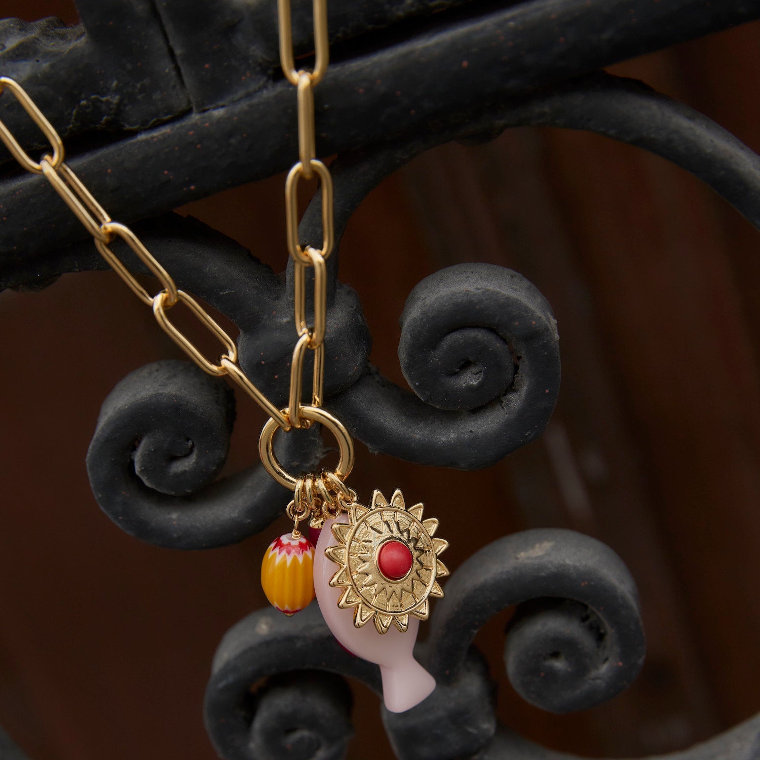 Necklace with a decorative pendant on an ornate metal background
