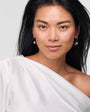 Woman wearing a white off-shoulder top against a plain background