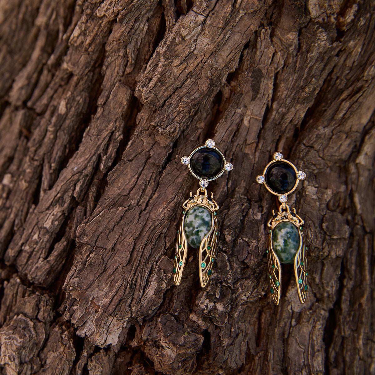 Cicada Inspired Black, Green and gold dangle earrings on tree bark