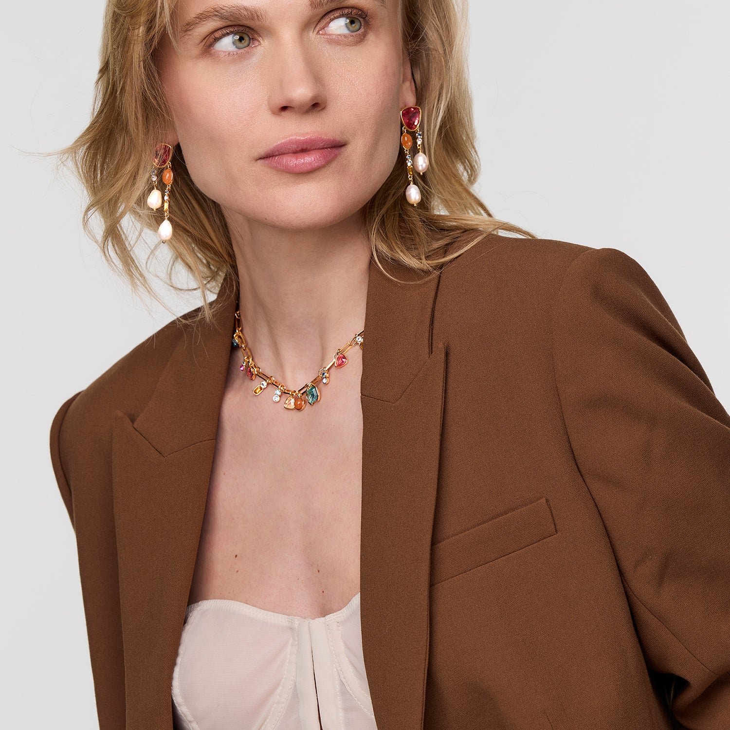Woman wearing a brown blazer and colorful Clara Luxe Earrings on white background