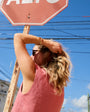 Model wearing pink vest outside with gold gold on wrist