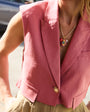 Person wearing a pink blazer with a blurred background