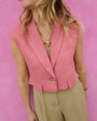 Person wearing a pink vest over a beige top against a pink background