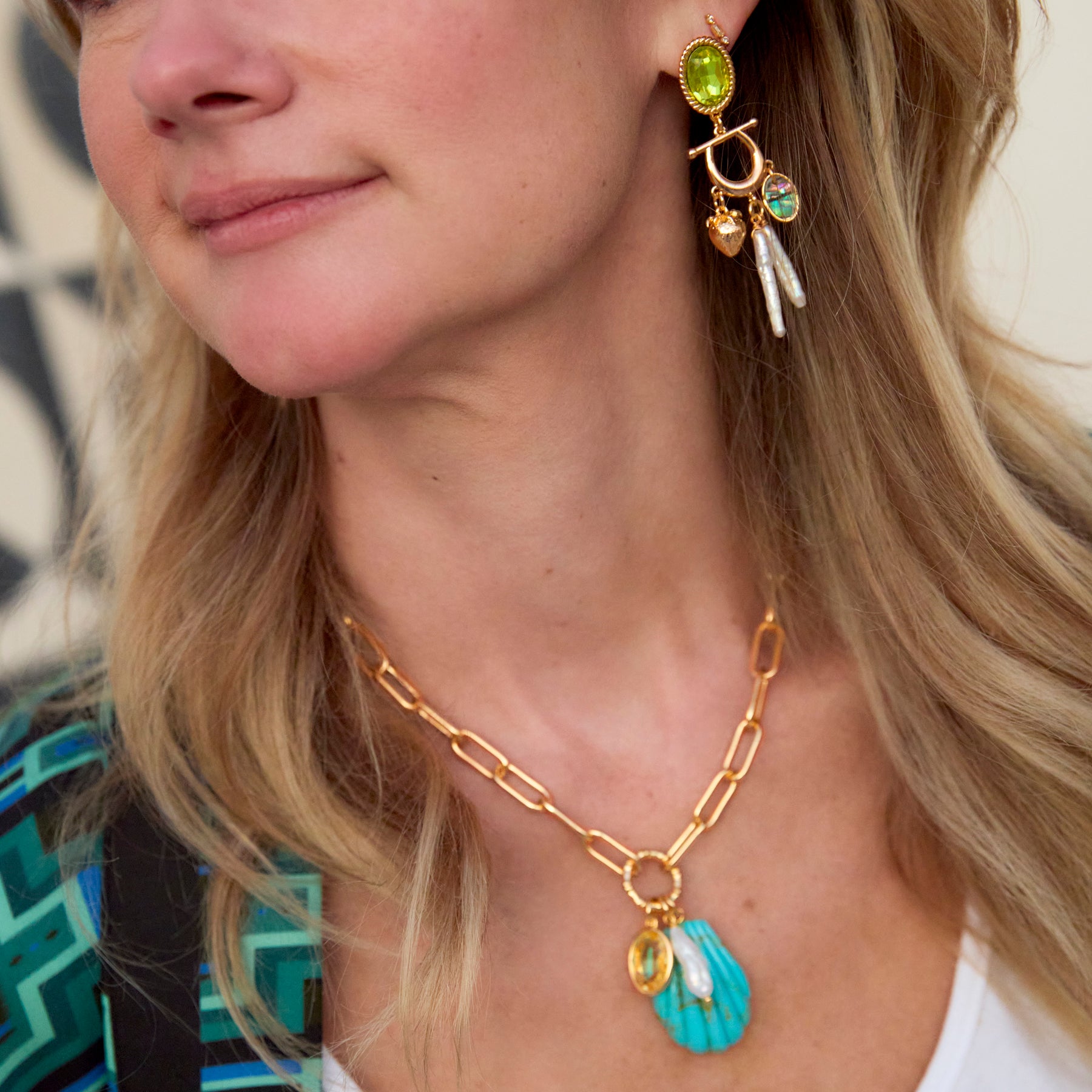 Model wearing colorful shell necklace and colorful earrings