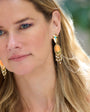 Close-up of a woman wearing gold earrings with a blurred background