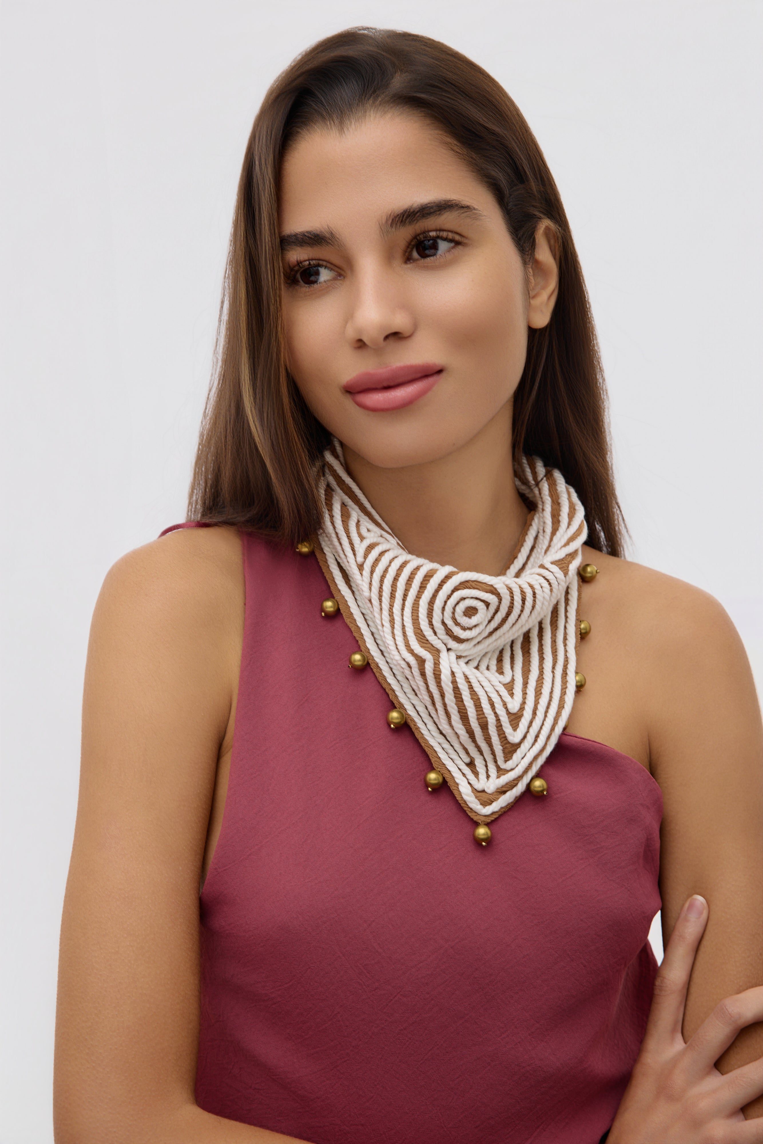 Woman wearing a decorative necklace with a plain background