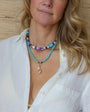 Woman wearing a colorful beaded necklace with a neutral background