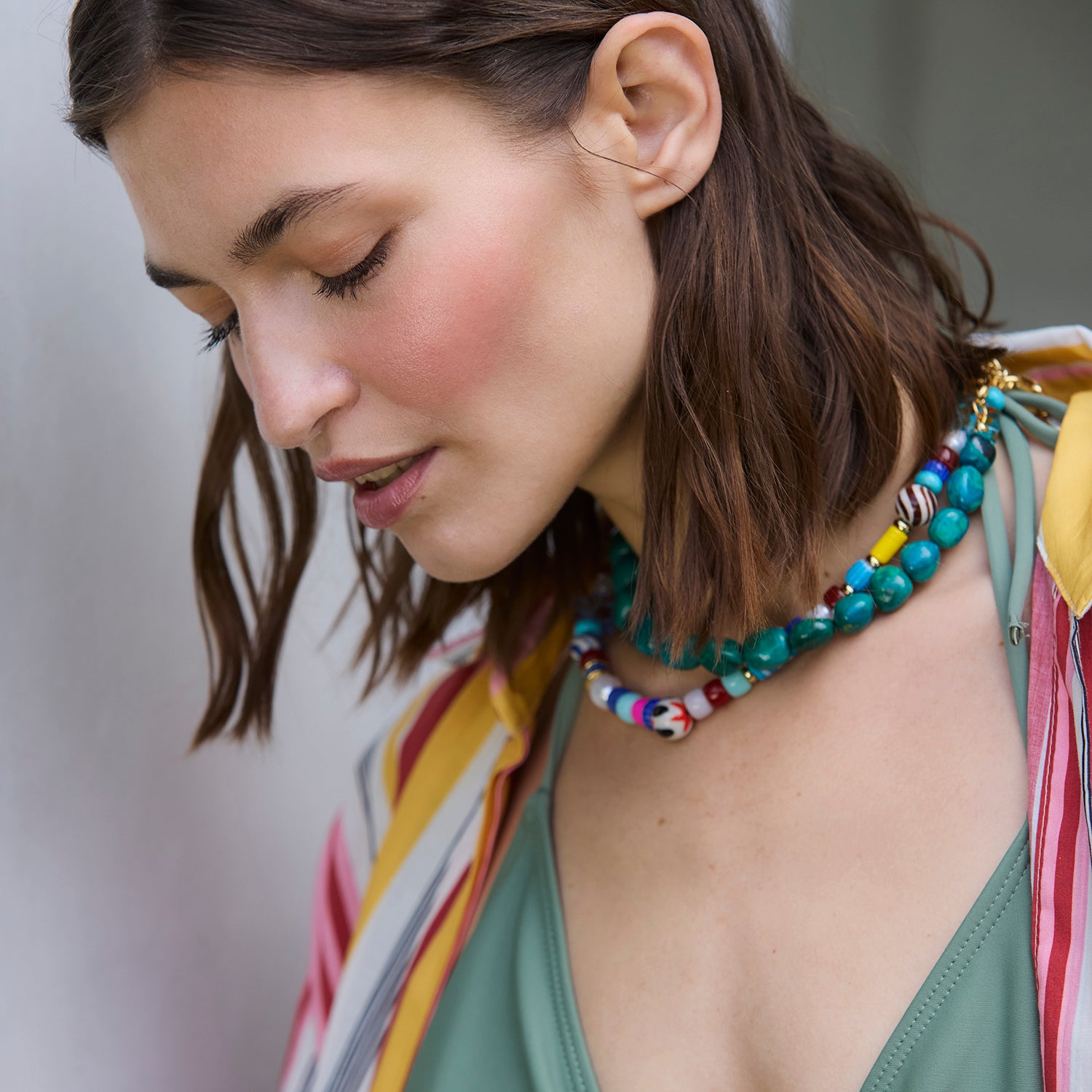 Woman wearing a colorful beaded necklace with a blurred background