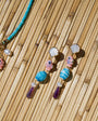 Necklace and earrings with shell and bead details on a woven surface