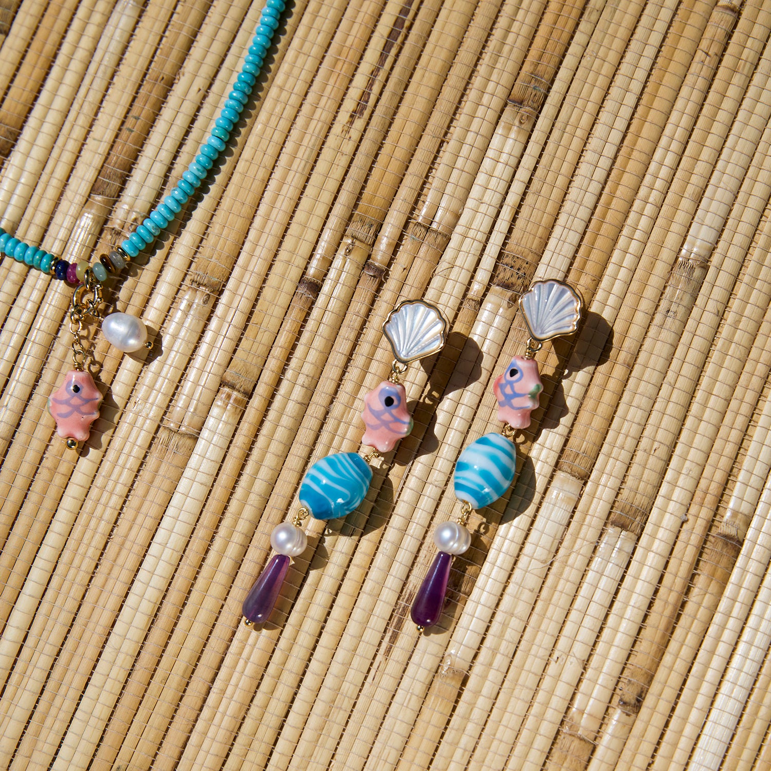 Necklace and earrings with shell and bead details on a woven surface