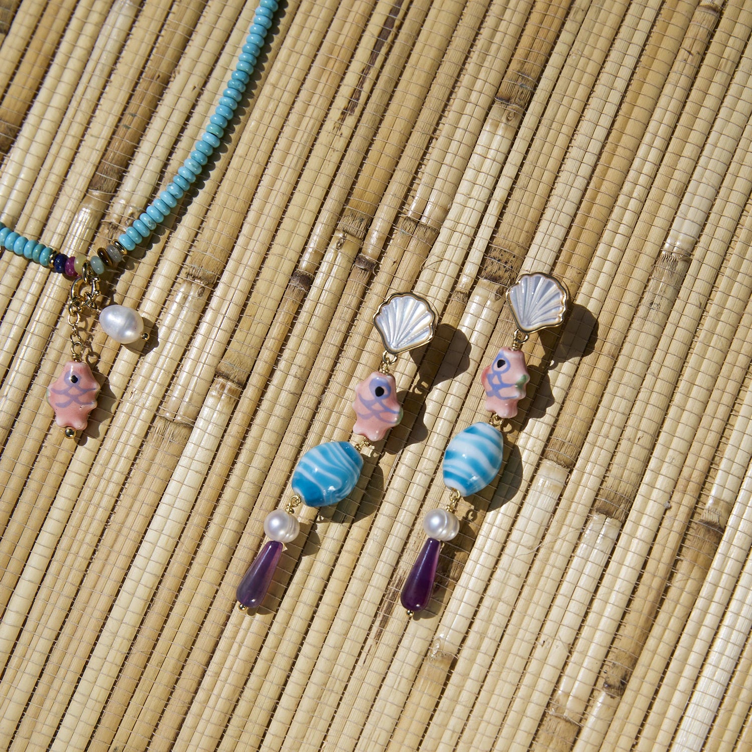 Necklace with shell and bead charms on a woven surface