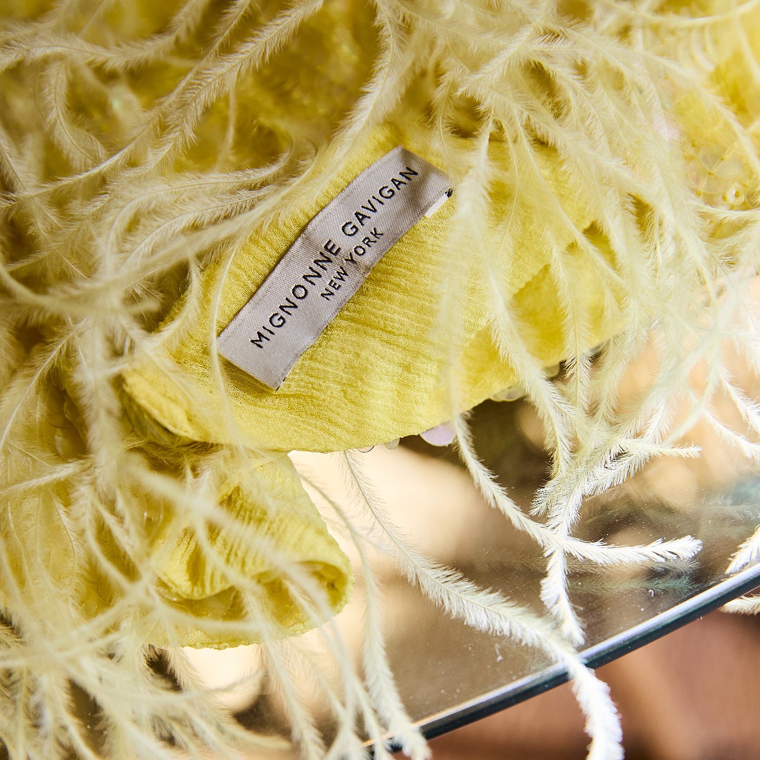 Yellow scarf with brand label on clear table