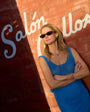 Woman in a blue dress standing against a wall with 'Salónillos' sign with Bianca Necklace on