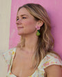 Woman with Pera Earrings against a pink wall