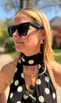 Maggie wearing gold hoop earrings in a polka dot black and white top 