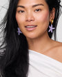 Woman wearing starfish-shaped earrings against a plain background