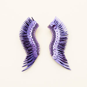 Metallic Purple Sequin Wing Earrings on Tan Background