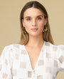 Metallic Gold Wavy Sequins on Thin Gold Hoop on Blonde Model with White Blouse On