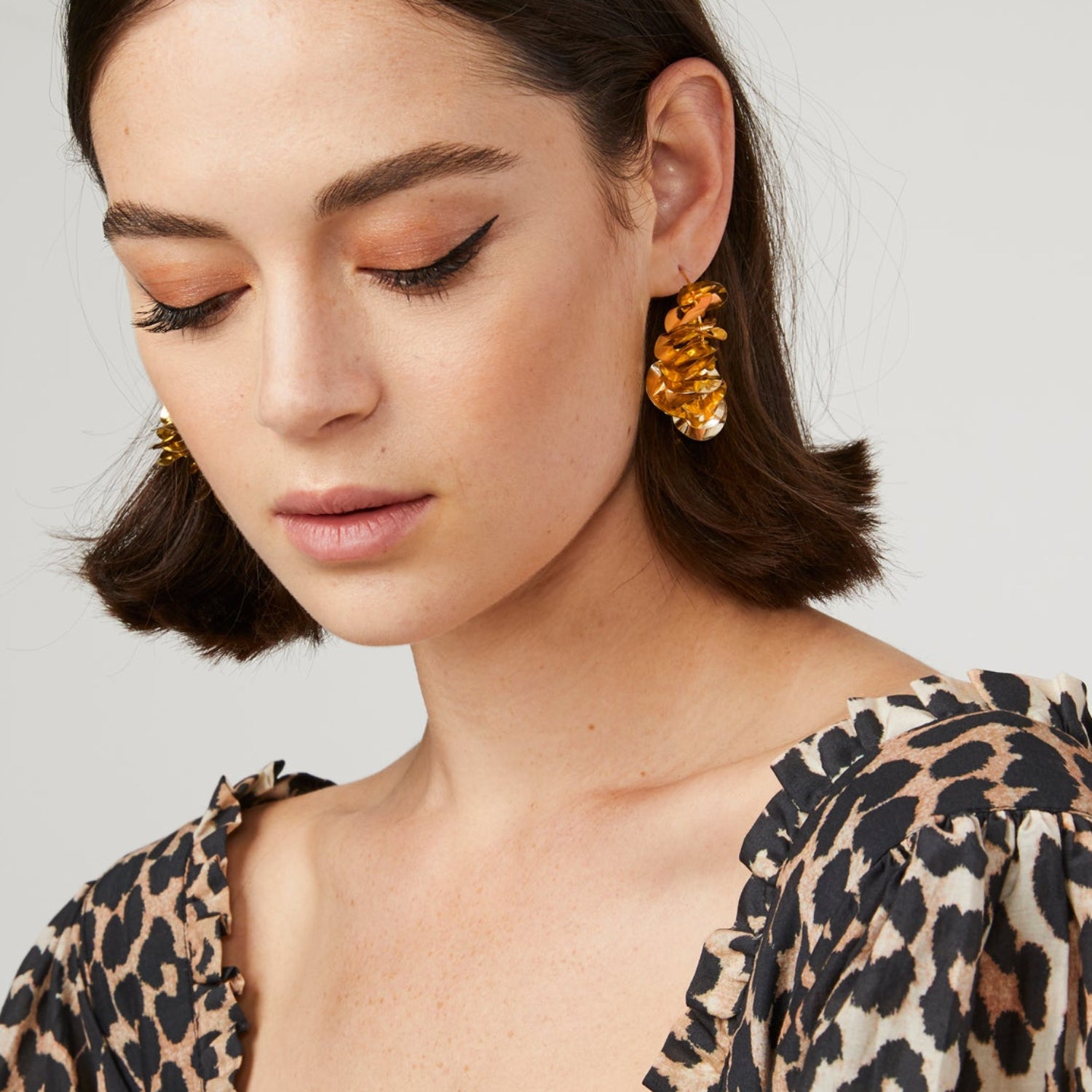 Metallic Gold Wavy Sequins on Thin Gold Hoop on Brunette Model with Cheetah Print Blouse