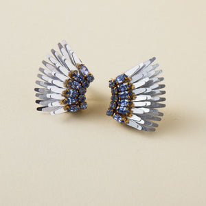 Metallic Silver Wing Stud Earrings with Blue Crystals on Tan Background