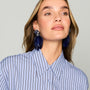 Navy feather drop earrings with ornate floral-inspired tops and gold-tone details on model looking left