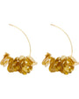 Pair of gold hoop earrings with leaf-like attachments on a white background