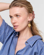 Woman wearing a blue striped shirt with a plain background