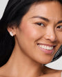 Model wearing crystal stud earring against white background