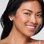 Model wearing crystal stud earring against white background