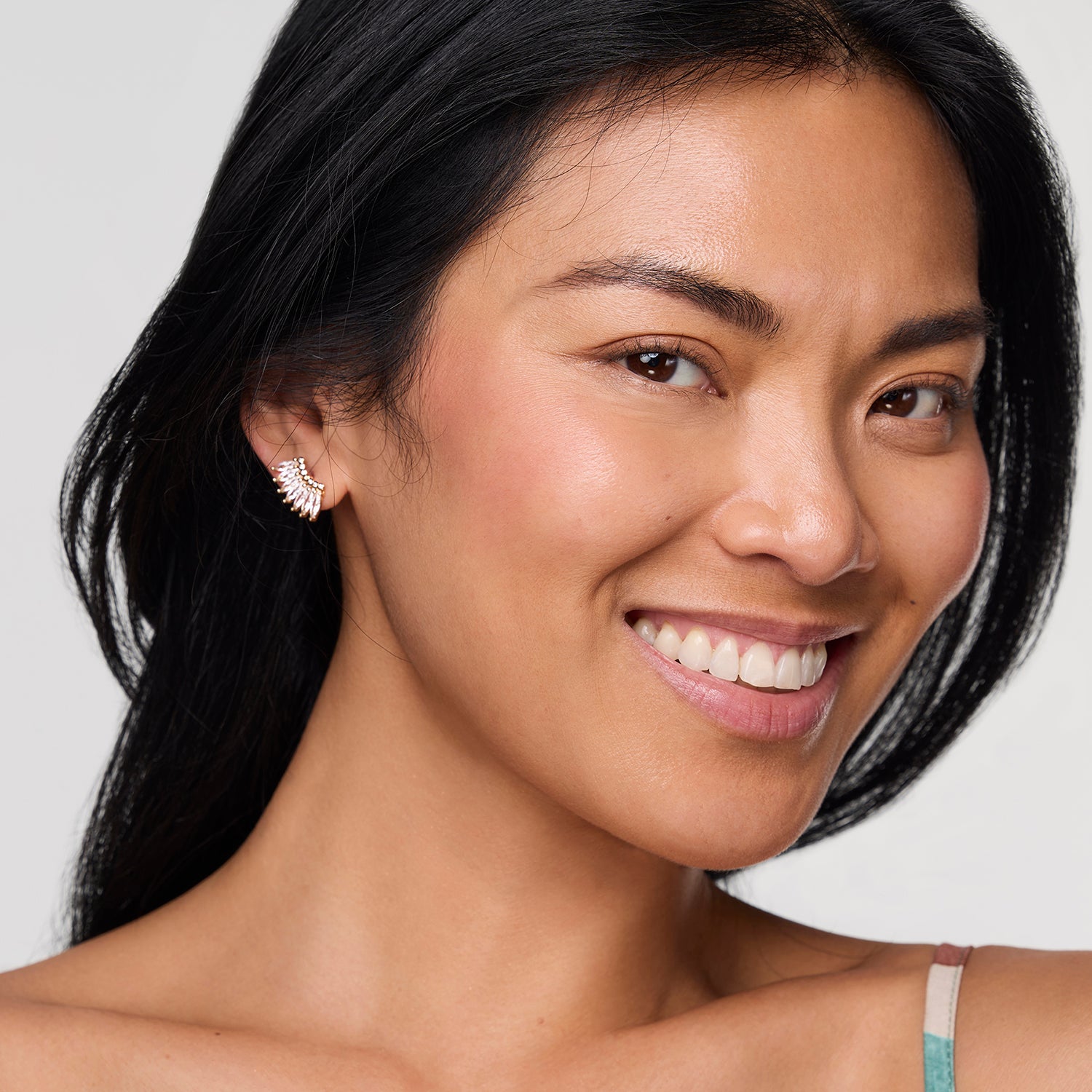 Model wearing crystal stud earring against white background
