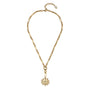 A gold chain necklace featuring a unique elongated link design and a central flower-shaped pendant with a textured center, displayed on a clean white background.