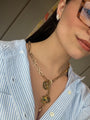 Person wearing a gold chain necklace with a blue and white striped shirt.