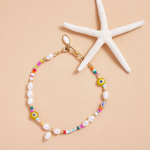 Multi-Colored Beaded and Pearl Anklet Styled with Starfish on Cream Background