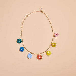 Multi-Colored Flower Charms on Gold Chain Necklace on Tan Background