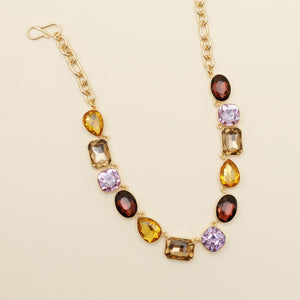 Purple, Yellow, Red, Brown Crystal Necklace on Gold Chain Staged on Tan Background