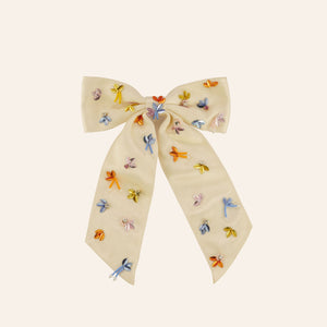 Multi-colored sequin and bead embroidered hair bow on tan background