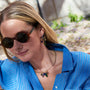 Gold-tone necklace featuring colorful green, blue, and clear pendants along a delicate chain on Mignonne Gavigan Lifestyle