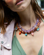 Model wearing beaded necklaces layered around her neck