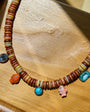 Necklace with multicolored beads and charms on a wooden surface