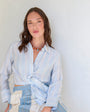 Woman wearing a light blue and white striped outfit against a white background