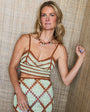 Woman wearing a patterned dress against a textured wall