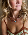 Woman wearing a colorful beaded necklace with a blurred background