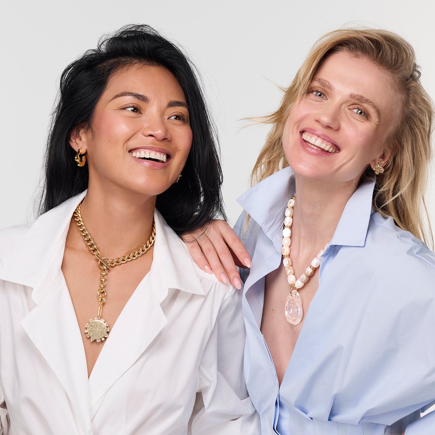 Two women wearing necklaces against a white background